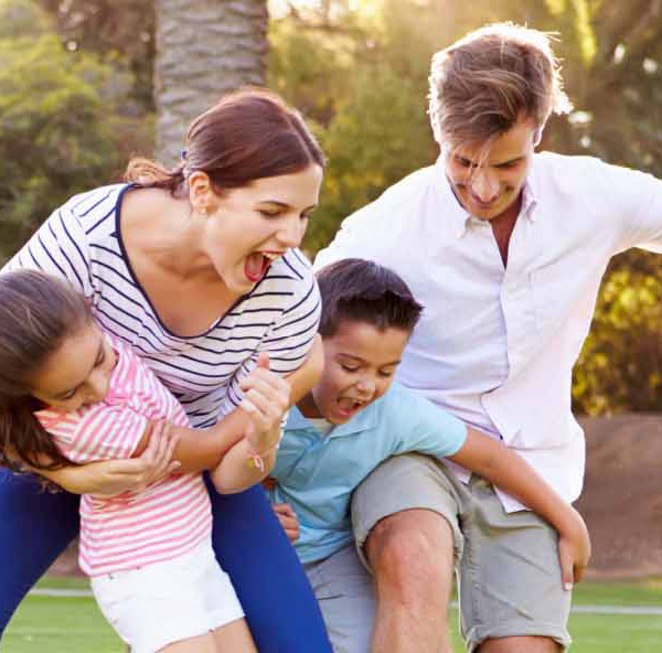 Happy family playing outside - parents and two children