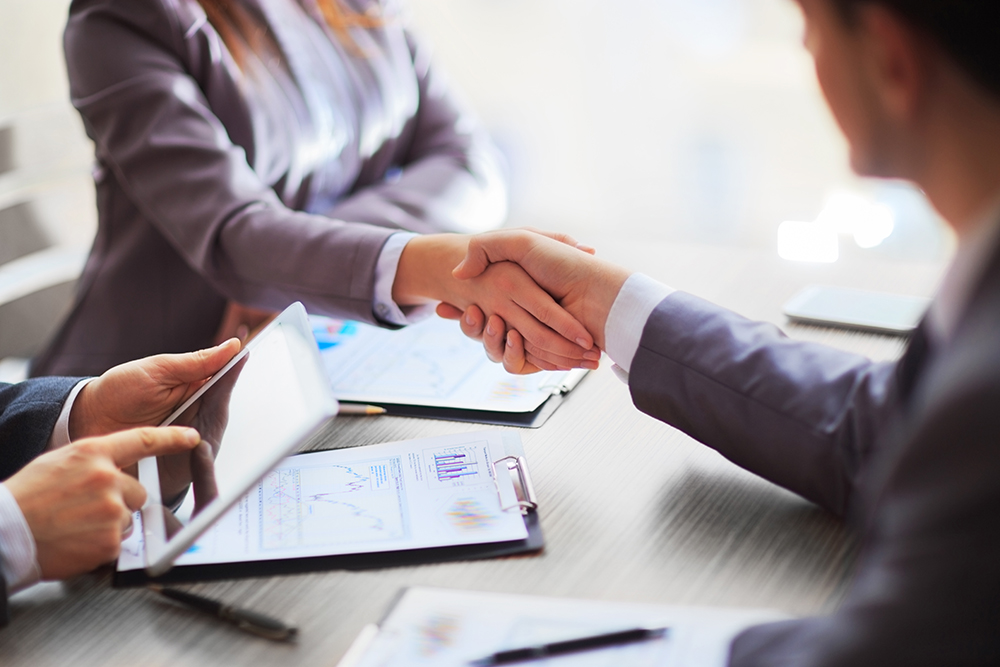 Businessman and woman shaking hands during a meeting