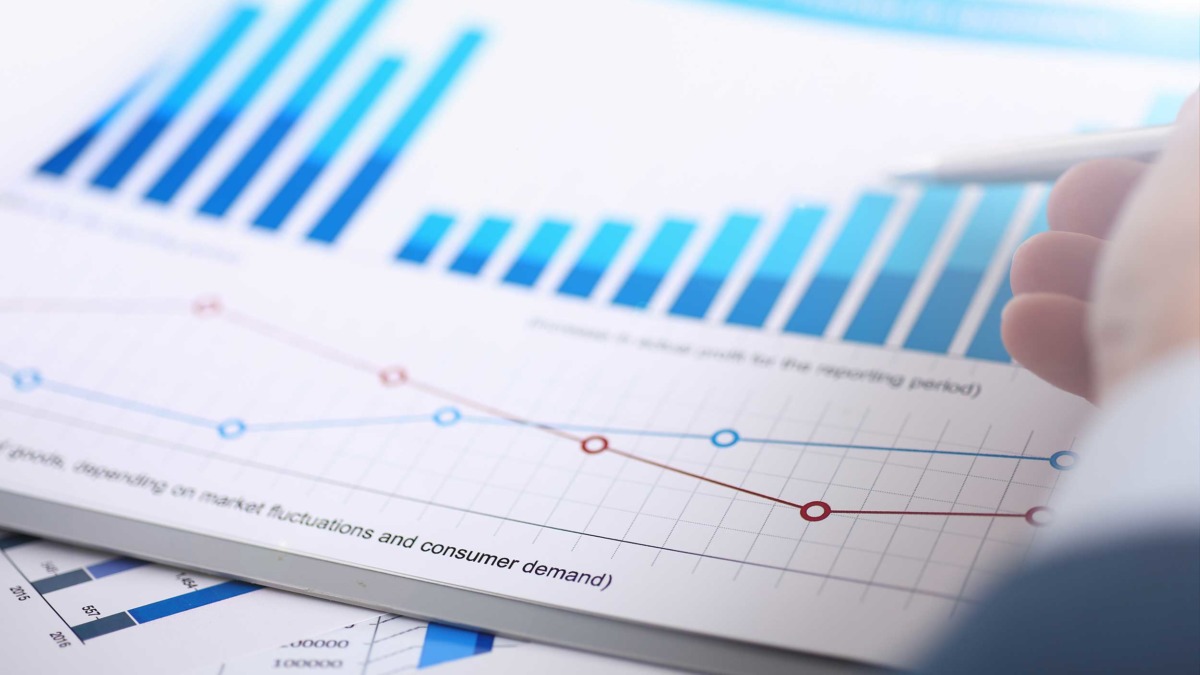 Pen pointing to a positively increasing chart representing an improvement in productivity and profitability