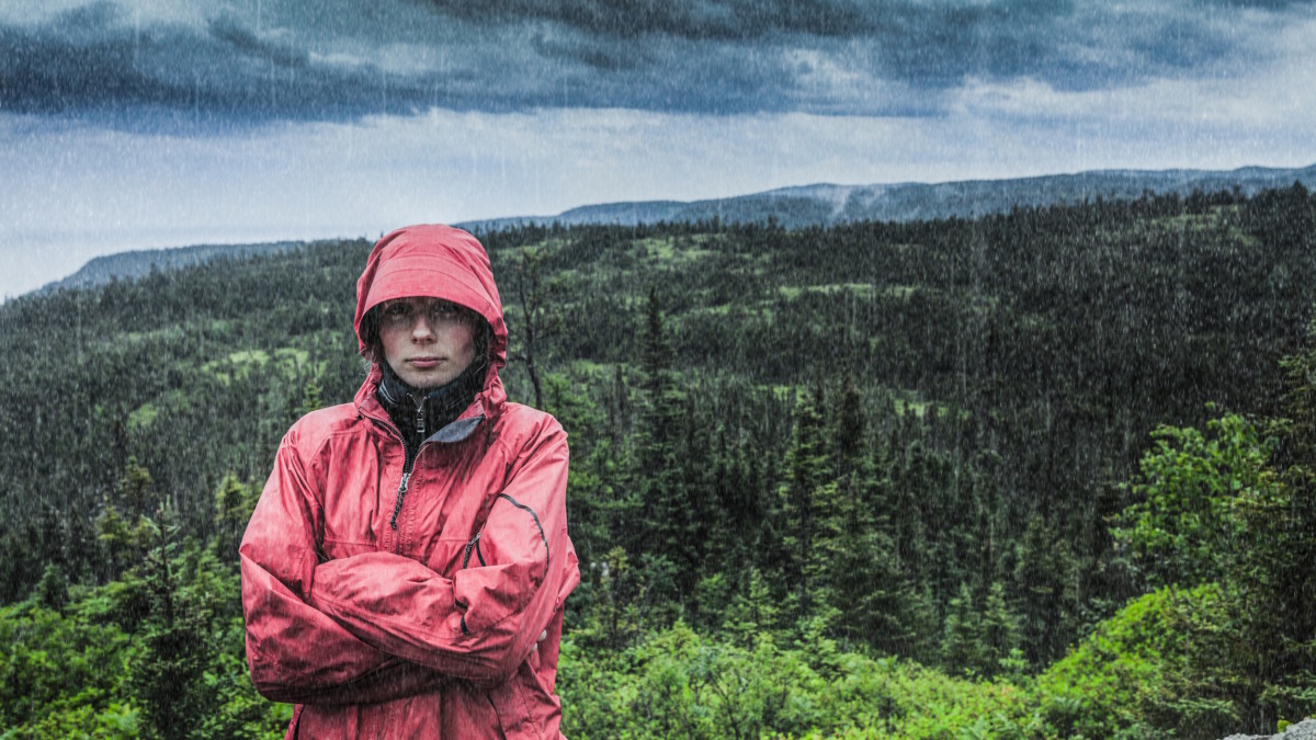 Unpredictable Heavy Rain Pouring on a Sad and Frustrated Young Woman Alone on top of a Mountain to demonstrate the pitfalls of software projects