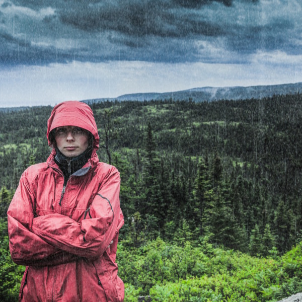 Unpredictable Heavy Rain Pouring on a Sad and Frustrated Young Woman Alone on top of a Mountain to demonstrate the pitfalls of software projects